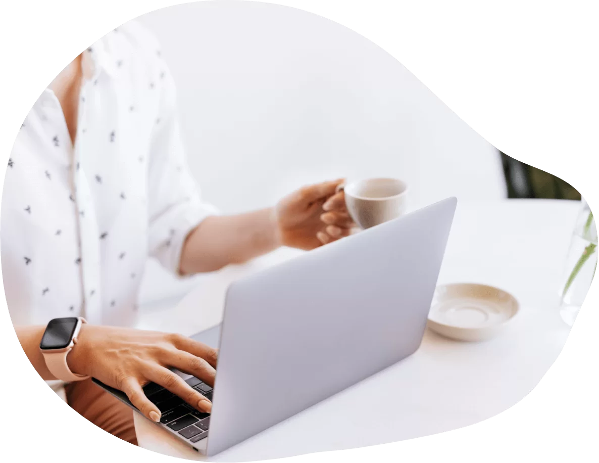 Mulher segurando uma caneca de café olhando para um laptop e enviando sua cotação para construção de site - AFC Web Design